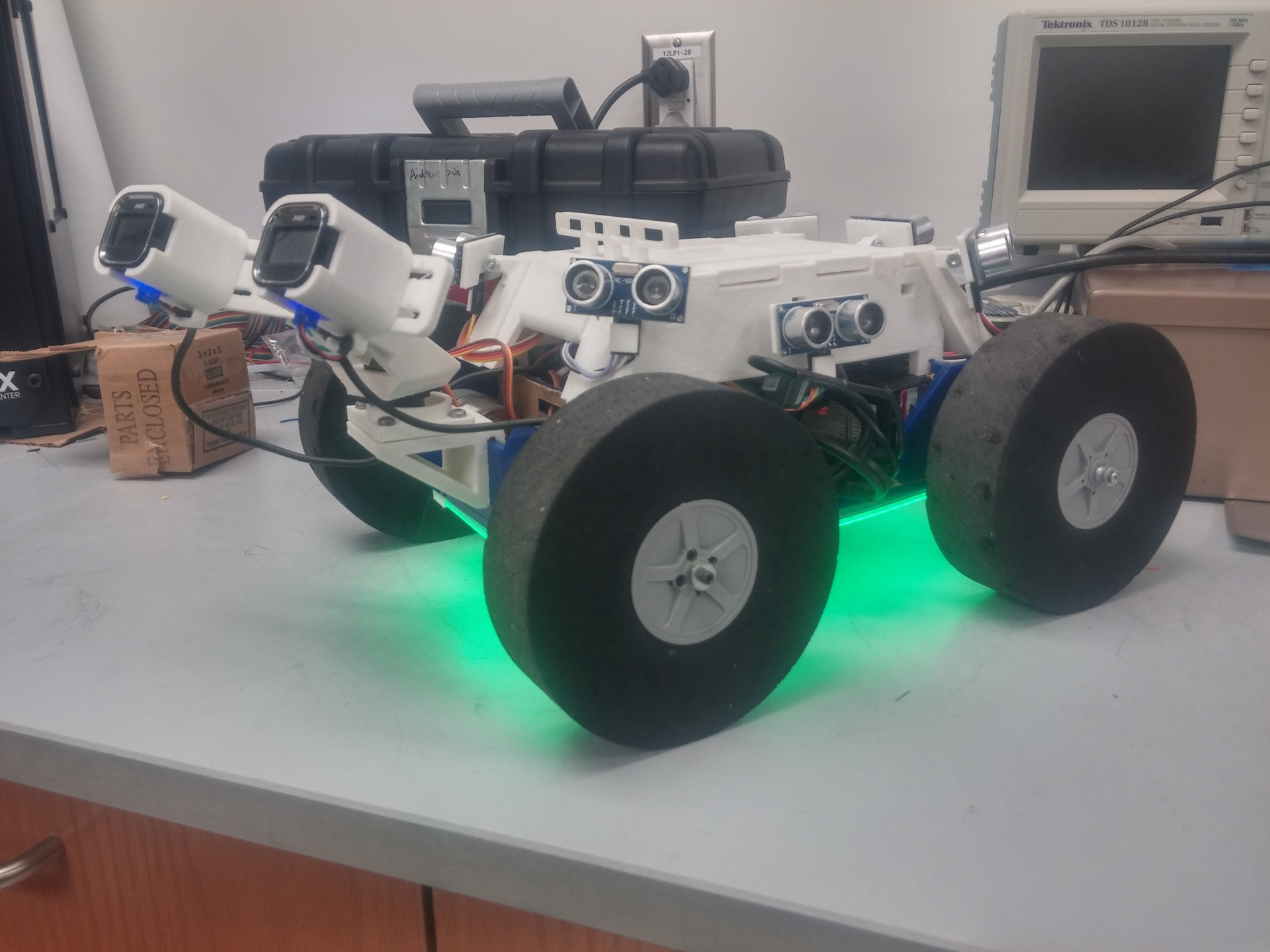 Side view of the rover, with the two front cameras tilted up, and LED strips on the bottom lit up green